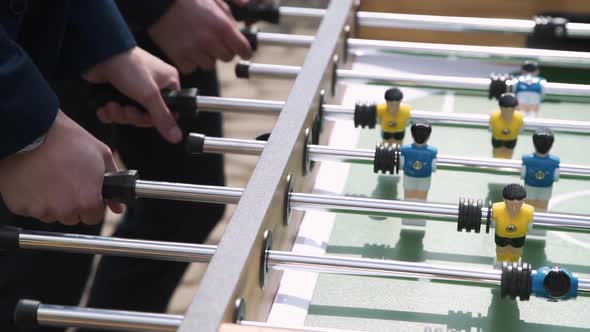 Man Actively Twists Handles of Table Kicker with Hands on Sunny Day Closeup alt