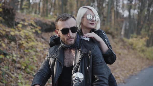 Stylish Blonde Leanes on Her Man's Back and Smiles in Park alt