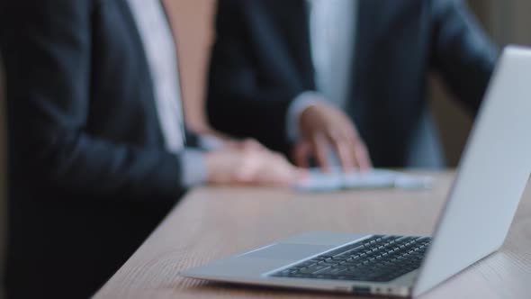 Closeup of Modern Laptop Computer Stands on Table in Office Against Background of Two Blurred alt