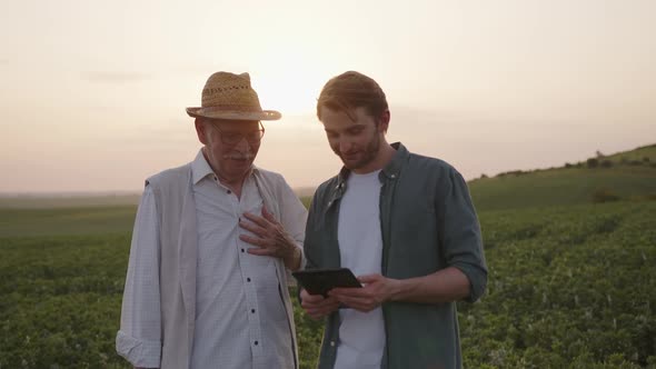 Close Up View of Two Farmers with a Black Tablet alt