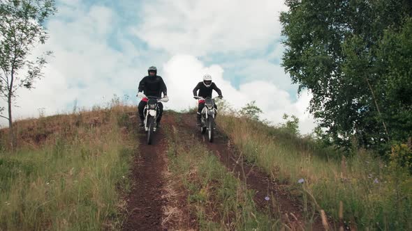 Slowmo of Motorcyclists Riding Downhill alt