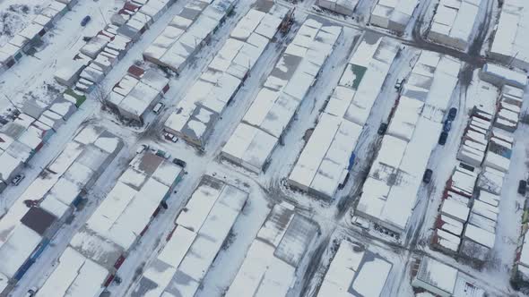 Aerial View of the Rows of Rooftops of Garages for Cars in a Guarded Parking Lot on a Winter Day alt