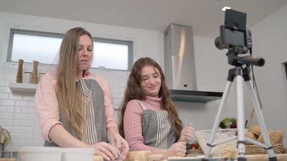 Mother and daughter live stream while cooking in the kitchen, Stock Footage