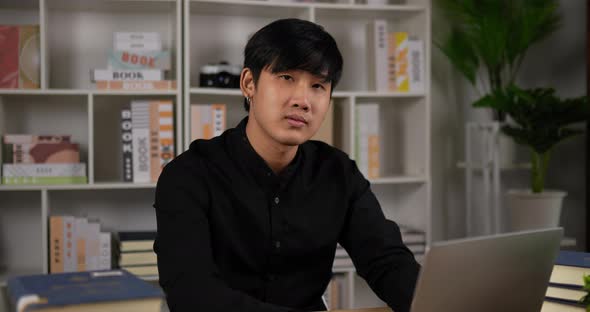 Creative man with laptop pointing at camera in office alt