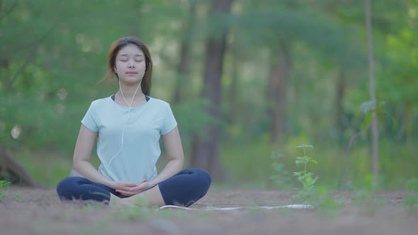 Asian cute girl She is doing yoga in the morning in the garden by the beach. alt