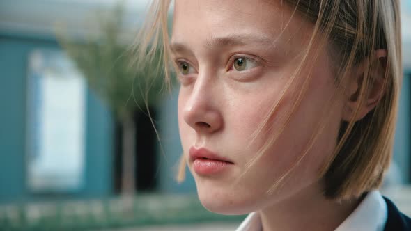 Close Up of Cute Girl, Baby Face, is looking thoughtfully, Wind is blowing her Hair. alt