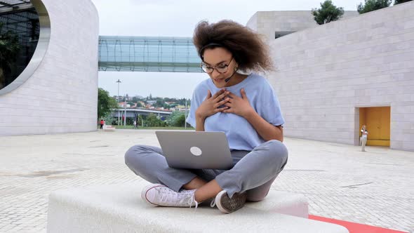 Busy Successful African American Young Woman with Headset Business Lady Sitting Outdoors Holds alt