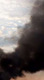 Column of Black Smoke in Sky Fire Burns Agricultural Debris Factory Pipe or Explosion alt