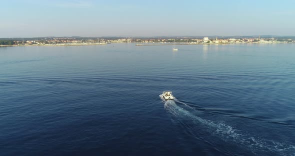 A Drone Shot of a Happy Family on a Summer Vacation Driving a Luxury Boat on the High Seas in the alt
