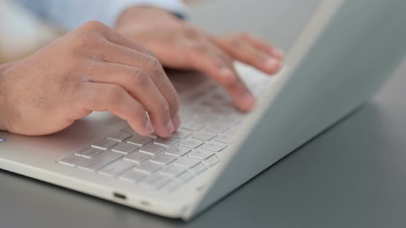 African Man Typing on Laptop Close Up alt
