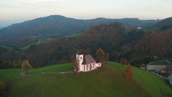 Amazing Beautiful Aerial View of the Hills, Colorful Forest and the Sv Sobota Church, Slovenia