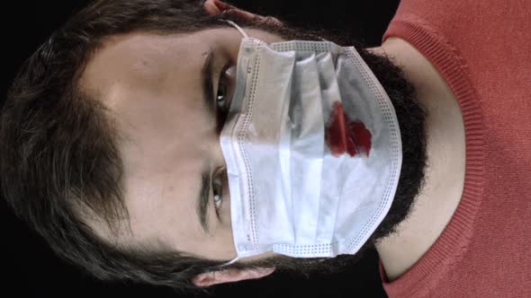 Vertical Shot Sick Man in Medical Mask with Blood on It Puts on New Mask