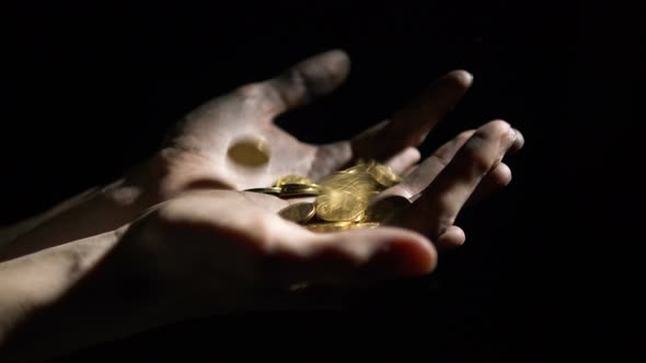 Gold Coins Falling Dirty Hands of Worker on Black Background. Concept of Jackpot Lottery alt