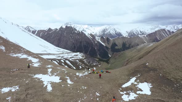 A Group of Tourists with Backpacks on the Pass over the Ridge.