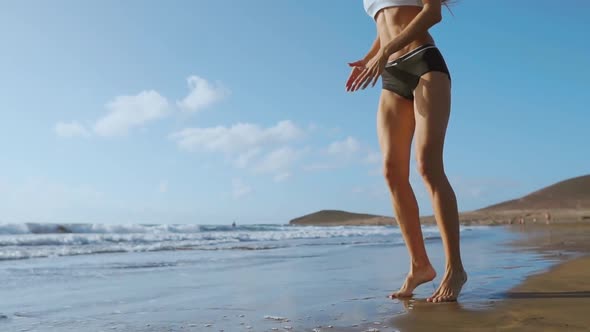 Beautiful Girl Athlete with Beautiful Breasts in Black Shorts and a White Top Crouches alt