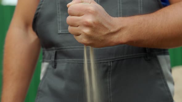 From the Man's Hand Clenched Into a Fist Pours Sand alt