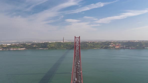 Aerial Hyperlapse of the Traffic Across Ponte 25 De Abril Bridge in Lisbon with Sanctuary of Christ alt