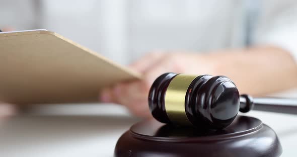 Female Hand Puts Signature on Document Against Background of Judge Wooden Gavel  Movie alt