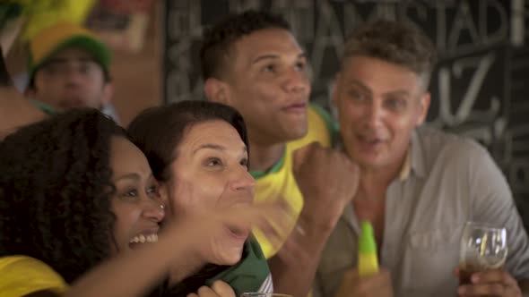 Football fans bonding while watching televised match at sports bar alt