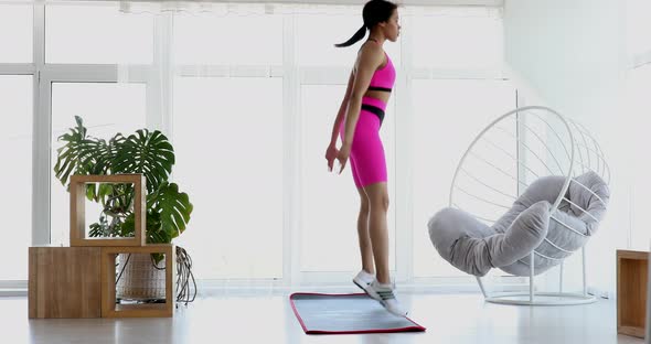 Black woman in sportswear doing workout  at home.