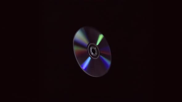 Compact Disc Glitter, Flies And Rotates On A Black Background In Slow Motion