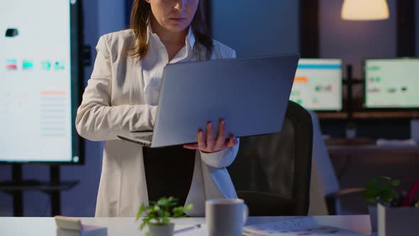 Tired Manager Raising Head Looking at Camera Sighing Holding Laptop alt