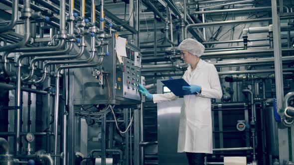 Female Specialist Is Writing Data From Plant Mechanism alt