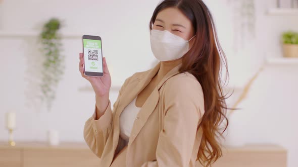 Pregnant woman holding and show COVID-19 vaccination passport on mobile phone alt