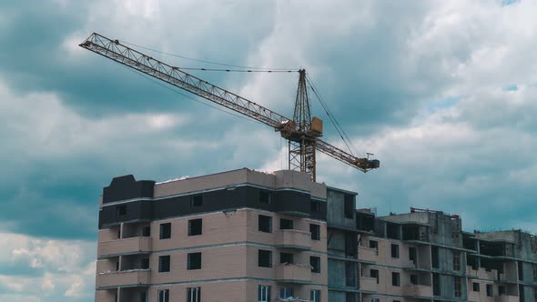 Timelapse footage of a high crane works on building site with a house alt