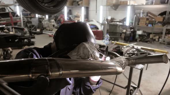 Welding Process.  A Man In Helmet Doing Argon Welding Parts  alt