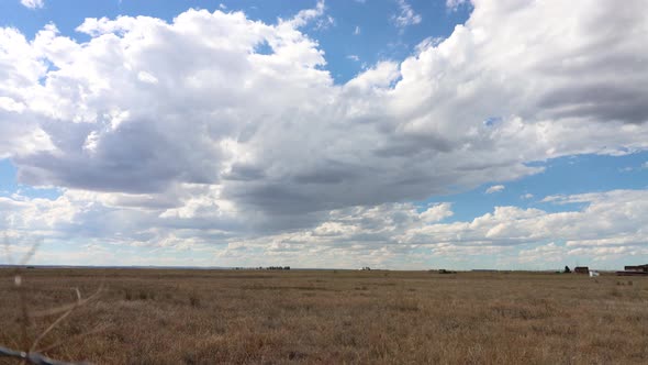 A western prairie time lapse with thousands of puffy white clouds and shadows crawling across the sk alt