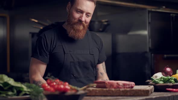 Happy chef cook holding steak