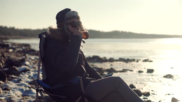 Man Warming Hands Steaming Cup Of Mate Tea. Male Hands With Mug Of Hot Drink Cold Winter Outdoors. alt