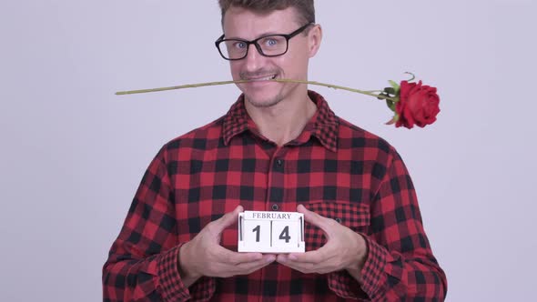 Happy Bearded Hipster Man Holding Calendar Block Ready for Valentine's Day alt