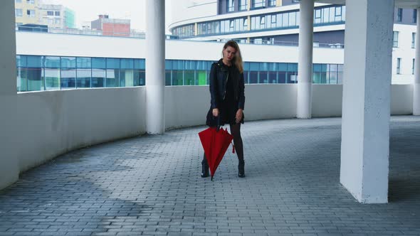 Girl Stands with Umbrella on Roof Looks Sadly alt