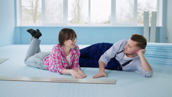 Married Couple Man and Wife Enjoy an Insulated Polystyrene Foam Floor Before Laying Laminate alt