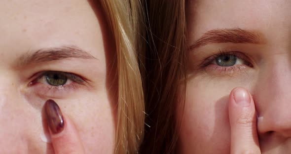 two girls close-up of faces plow their faces with white cream. young blonde women skin care natural alt
