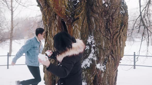 Young Asian Couple Having Snowball Fight alt
