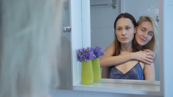 Reflection of Two Pretty Female Friends in Mirror alt