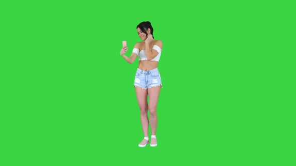 Beautiful Young Woman Doing Selfie on a Green Screen, Chroma Key. alt