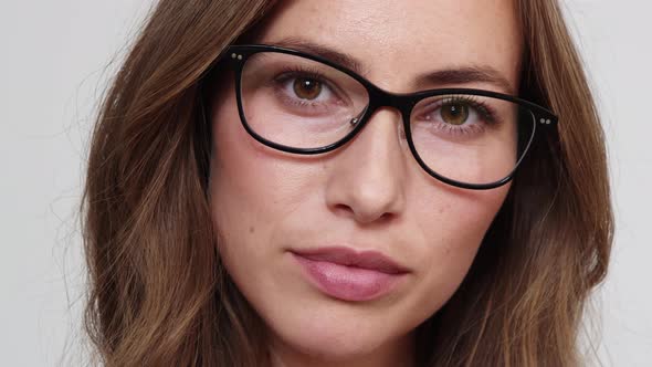 Woman with Brown Eyes Holding Her Glasses while Looking Seductively at Camera