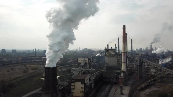 Smoke and soot from a steel mill. Aerial view at dawn. Harmful production and air pollution alt
