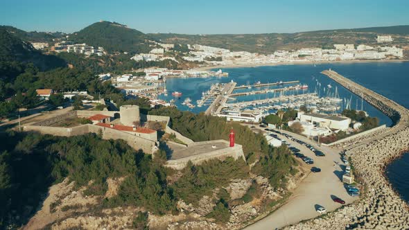 Aerial view of Sesimbra touristic attraction, lighthouse and fortress on hills