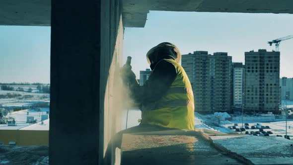Side View of a Cement Wall Getting Buffed By a Male Worker alt