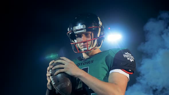 American Football Player Holding a Ball in Hands, Close Up alt