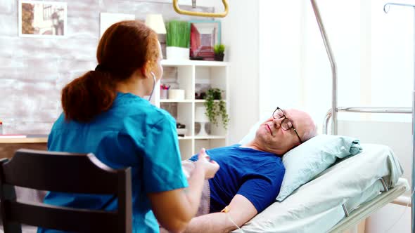 Old Sick Man in a Hospital Bed Gets His Heartbeat Checked alt