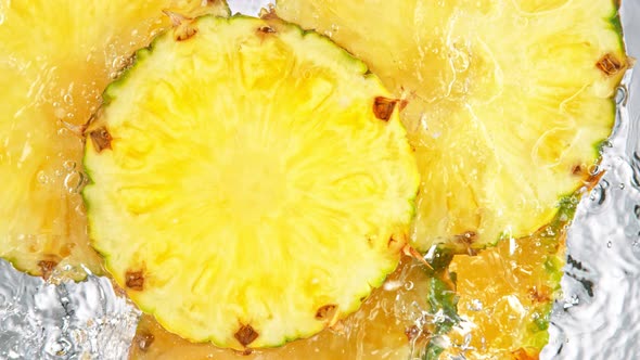 Super Slow Motion Shot of Splashing Fresh Pineapple Slices Into Water at 1000 Fps alt