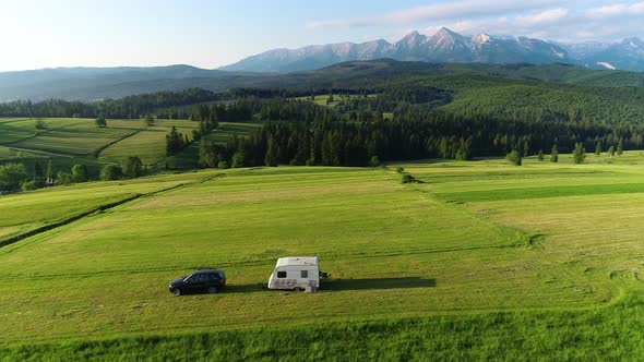 Trailer Caravaning alone in the mountains. Aerial view of RV car with trailer caravan.