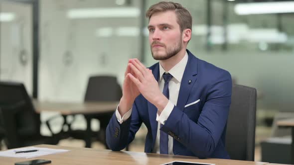 Pensive Young Businessman Thinking at Work alt