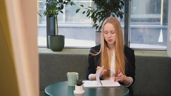 Young Blond Woman is Working in Cafe Restaurant